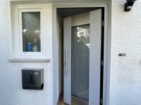 Haustür gräulich mit breiten Milchglas-Lichtausschnitt geöffnet